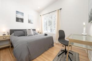 een witte slaapkamer met een bed en een bureau bij Contemporary renovated house in southshore MTL in Brossard