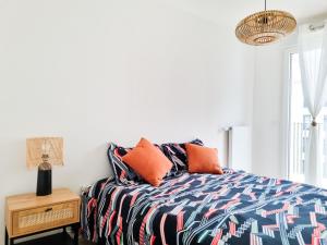 um quarto com uma cama com almofadas laranja em EXIGEHOME-Beautifull T4 near Paris La Défense-Champs Elysée em Rueil-Malmaison