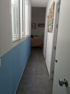 um corredor com paredes azuis e uma janela em Sopranis del MAR Apartamento centro Cádiz, junto playa y estación em Cádis