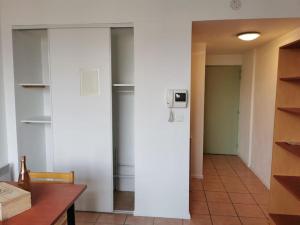 eine Küche mit einem Kühlschrank in einem Zimmer mit einem Tisch in der Unterkunft Superbe Studio de 23m² in Nîmes