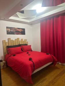 a bedroom with a large red bed with red curtains at La Maison des Plaisirs Love room in Champigny-sur-Yonne
