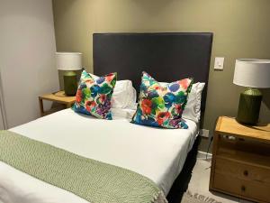 a bedroom with a bed with two pillows on it at Zimbali Boulevard Suites 159 in Ballito