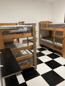 - 2 lits superposés dans une chambre avec un sol en damier dans l'établissement Cabana Alvorada Hostel, à Balneário Camboriú
