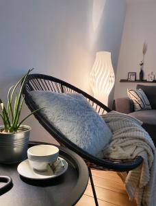 a room with a rattan chair and a table at Apartman Riva in Kraljevo