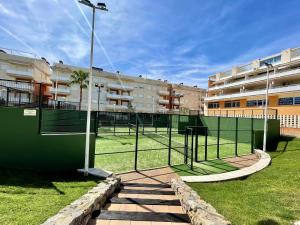 einen Tennisplatz vor einem Gebäude in der Unterkunft Apartamento con vistas al mar piscina padel in Barrio-Mar