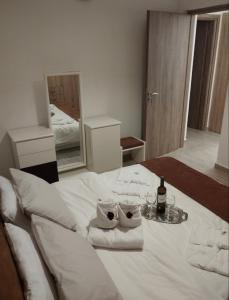 un letto bianco con due asciugamani e una bottiglia di vino di KaZa ad Antimácheia