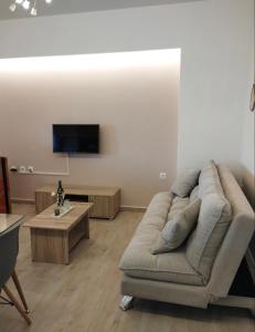 a living room with a couch and a flat screen tv at KaZa in Antimácheia