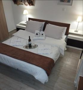 Un dormitorio con una cama con una botella de vino. en KaZa en Antimácheia