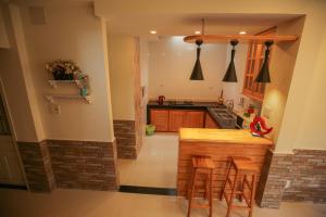 a kitchen with a counter and some chairs in it at Nhà Của Thỏ Vân Anh in Da Lat