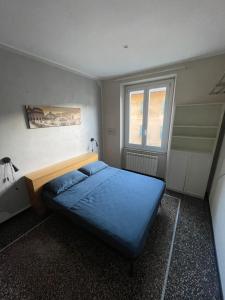 Un dormitorio con una cama azul y una ventana. en Casa Alizeri FREE PARKING COPERTO, 2 min a piedi, en Génova 1 foto más