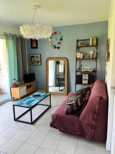 a living room with a bed and a mirror at Ecrin de verdure Entre forêt et océan in Saint-Martin-de-Seignanx +22 photos