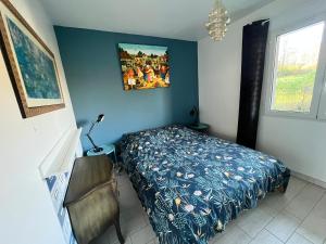 1 dormitorio con 1 cama y una foto en la pared en Ecrin de verdure Entre forêt et océan en Saint-Martin-de-Seignanx