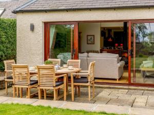 a wooden dining table and chairs in a garden at 3 bed property in Swinton 89133 in Swinton