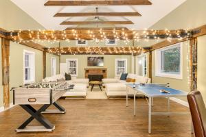 - un salon avec une table de ping-pong et des lumières dans l'établissement Rockspring by AvantStay Huge Berkshires Estate, à Stockbridge