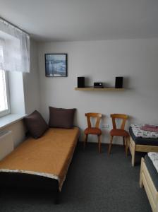 Habitación con 1 cama y 2 sillas. en Apartmán Lanžhot, en Lanžhot