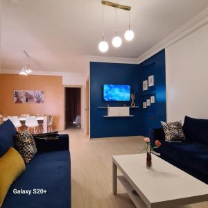 ein Wohnzimmer mit blauen Wänden und einem blauen Sofa in der Unterkunft Appartement complexe dream hills in Tangier
