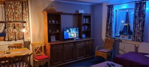 a living room with a tv on a cabinet at Landhaus Eibelesee in Oberstaufen