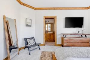 a bedroom with a bed and a tv on the wall at Murdock by AvantStay Cozy Townhouse w Hot Tub Walk To Park City Mountain in Park City