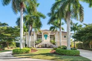 a house with palm trees in front of it at Tropical Pool Paradise - Minutes from the Beach Venice in Nokomis