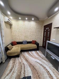 a living room with a couch and a television at Квартира в центре города Тирасполь! Тихий и удобный район! in Tiraspol