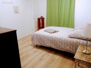 - une chambre avec un lit et une table avec une lampe dans l'établissement Apartment de Charme, à Bordeaux