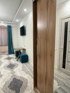 Habitación con puerta de madera y escritorio. en City hotel, en Karakol