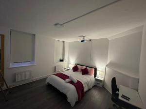 a white bedroom with a bed with red pillows at Super double bedroom zone 1 in London