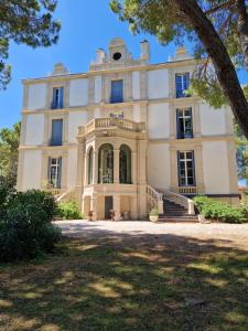 une vieille maison avec des escaliers en face de celle-ci dans l'établissement Château de Bayssan, à Béziers