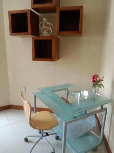 a blue desk with a chair and a vase with a flower at Casa Berth lu in Oaxaca City