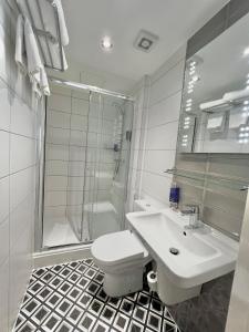 a bathroom with a toilet and a sink and a shower at The Eaton Townhouse in London