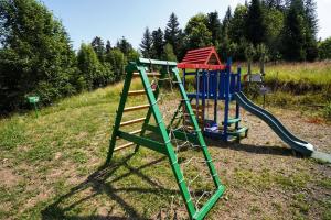 a playground with a slide in a field at Gorski park Kupjak in Kupjak