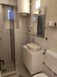 a bathroom with a sink and a toilet and a mirror at Guesthouse Kruna Višegrad in Višegrad