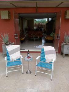 two chairs and a table in front of a building at Casa Berth lu in Oaxaca City