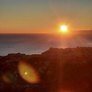 una puesta de sol sobre el océano con el sol en el cielo en Dal Moro 44 