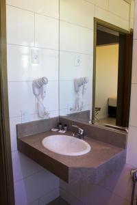 a bathroom with a sink and a mirror at Porto das Asas Park Hotel in Andradas