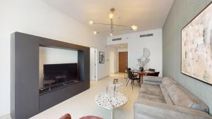 a living room with a couch and a flat screen tv at Primestay - Prime Views 1BR, Meydan in Dubai