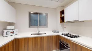 a kitchen with a sink and a microwave at Primestay - Prime Views 1BR, Meydan in Dubai