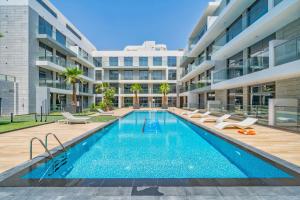 a swimming pool in front of a building at Primestay - Prime Views 1BR, Meydan in Dubai