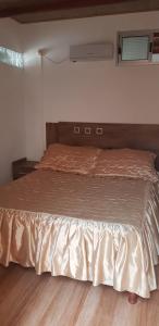 ein großes Bett in einem Schlafzimmer mit Holzboden in der Unterkunft La Quimera del Águila in Atlántida