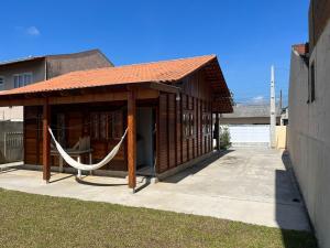 ein kleines Holzgebäude mit einer Hängematte. in der Unterkunft Casa do Kélvio in Penha