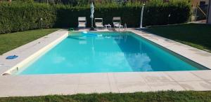 een zwembad met twee stoelen in een tuin bij Casa Amedeo in Lucca