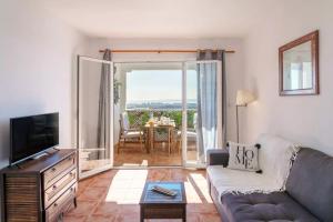 un salon avec un canapé et une télévision dans l'établissement "Servall Host" Alicante 2 Piscines et Parking privé, à Mutxamel