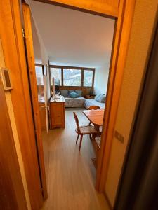 ein Zimmer mit einem Tisch und einem Zimmer mit einem Sofa in der Unterkunft Sasso Rosso Apartment in Folgarida