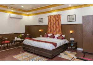 Cette chambre comprend un grand lit avec des oreillers rouges. dans l'établissement HOTEL HARMONY, KHAJURAHO MADHYA PRADESH, à Khajurâho