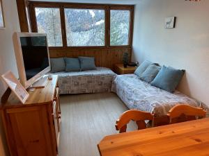 a room with two beds and a television in it at Sasso Rosso Apartment in Folgarida