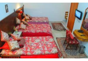 - une chambre avec deux lits, une table et une chaise dans l'établissement HOTEL HARMONY, KHAJURAHO MADHYA PRADESH, à Khajurâho