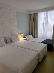 two white beds in a hotel room with a window at Legendary Porto Hotel in Porto +34 photos