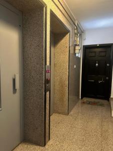 einen Flur mit schwarzer Tür und einen Weg zu einem Zimmer in der Unterkunft Daire Plaja Sadece 700 M Uzaklıkta in Antalya