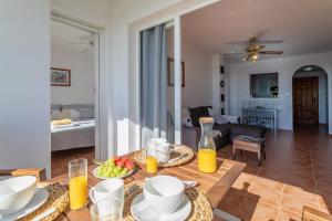 ムチャメルにあるGolf Bonalba Alicante "Servall Host"のリビングルーム(テーブル、食べ物、オレンジジュース付)