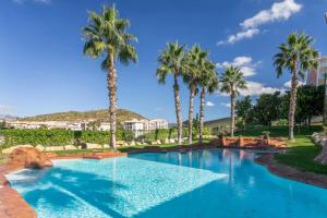 une piscine avec des palmiers dans un complexe hôtelier dans l'établissement "Servall Host" Alicante 2 Piscines et Parking privé, à Mutxamel